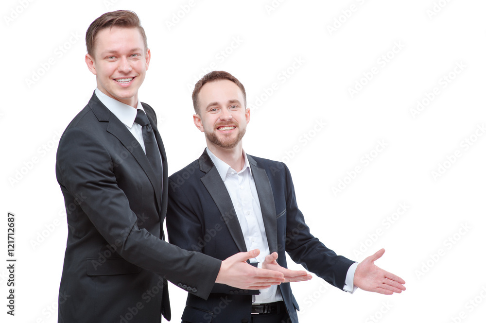 Advertising your product. Two happy young businessmen pointing copy space and smiling at camera while standing isolated on white Advertising your product. Two happy young businessmen pointing copy space and smiling at camera while standing isolated on white