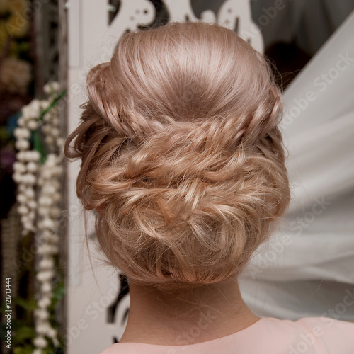 Beautiful wedding hairstyle. The bride's hairstyle in the beauty salon. Rear view.