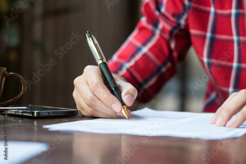 A man is writing on a paper.