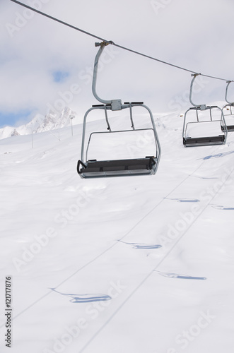 Foto empty free chair ski lift on the snowboard resort with shadows on white snow background in mountains
