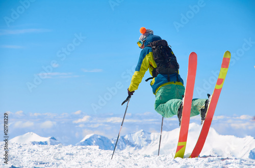 Extreme ski rider watch to mountains in perfect pose. Beautiful winter sport or games concept. Interesting adventure for holiday or weekend. Color snowboard rider. photo