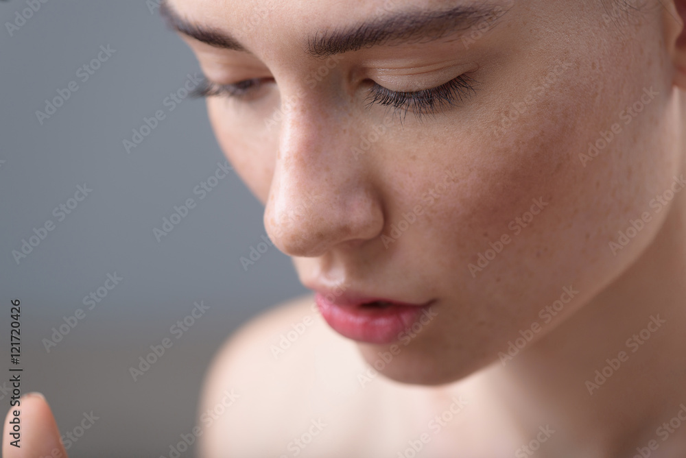 girl face with freckles on grey background and copy space girl face with freckles on grey background and copy space