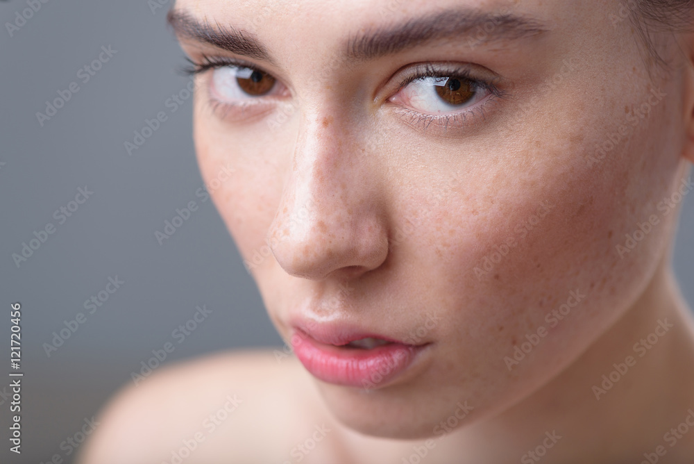 freckled attractive woman portrait on grey background freckled attractive woman portrait on grey background
