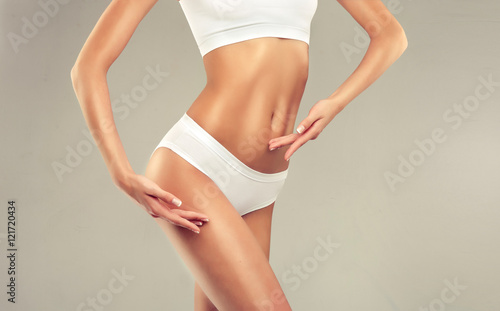 Slim tanned woman Perfect Body . Slim toned young body of the girl . An example for sports and fitness or plastic surgery and aesthetic cosmetology 