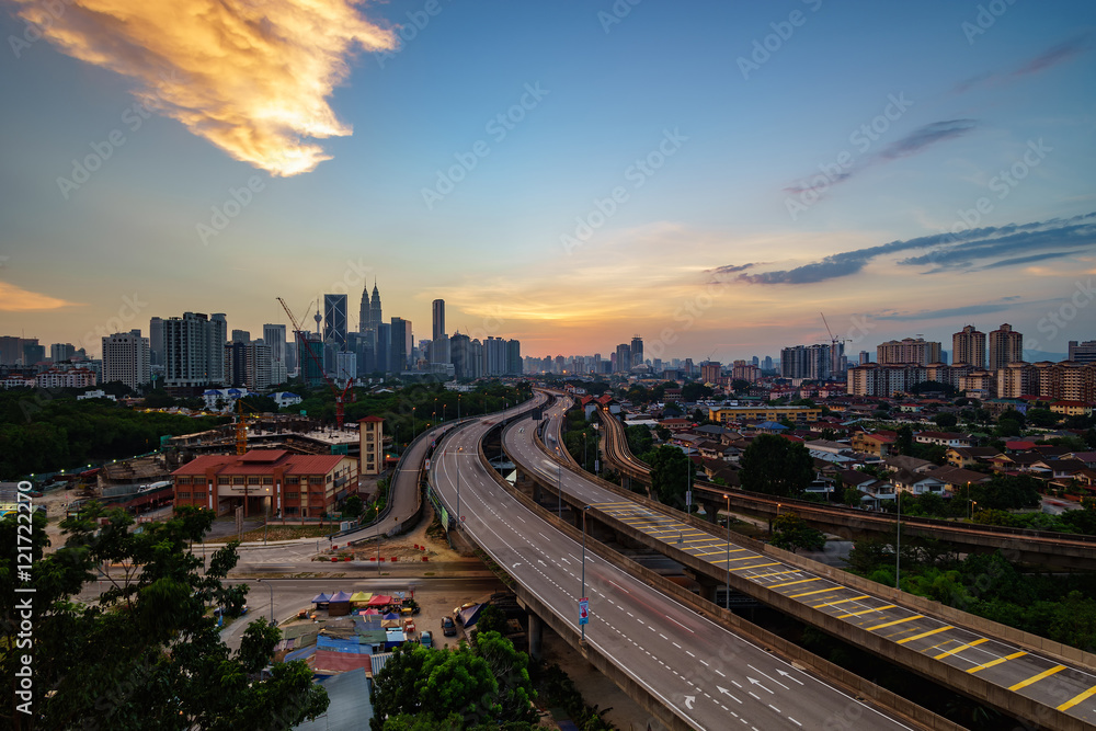 Dramatic scenery of elevated highway heading towards Kuala Lumpur city center at sunset.