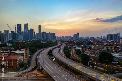 Dramatic scenery of elevated highway heading towards Kuala Lumpur city center at sunset.
