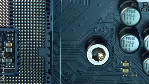 close up dolly shot over a printed circuit board with soldered electronic parts