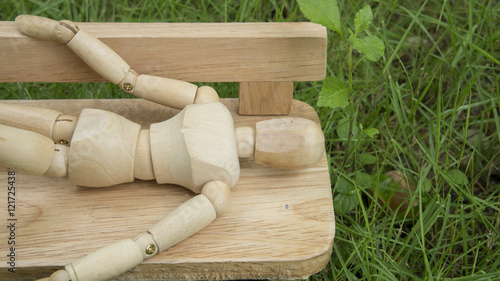 фотографія wooden human figure sleep bench garden