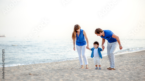 Man woman and child run on the beach near the ocean and feel happy © freshstockplace