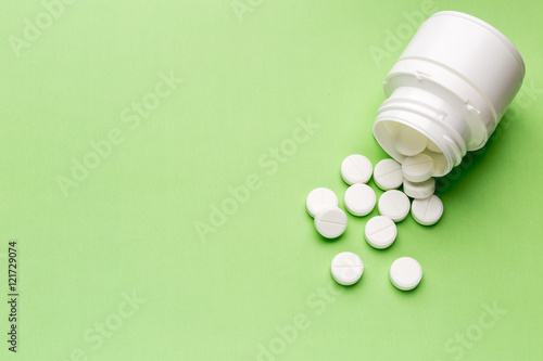 Round white pills and plastic pill bottle