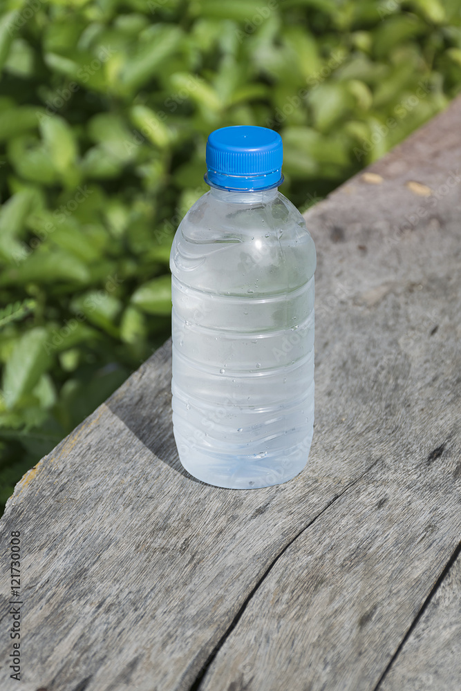 Water bottle on wood table with nature background. Fresh and energy concept. Water bottle on wood table with nature background. Fresh and energy concept.