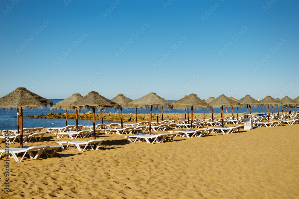 Blue sky and straw umbrella on a beautiful tropical beach background Blue sky and straw umbrella on a beautiful tropical beach background