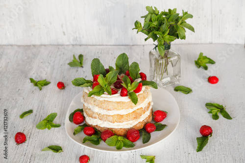 Homemade cake decorated strawberry and mint on white background