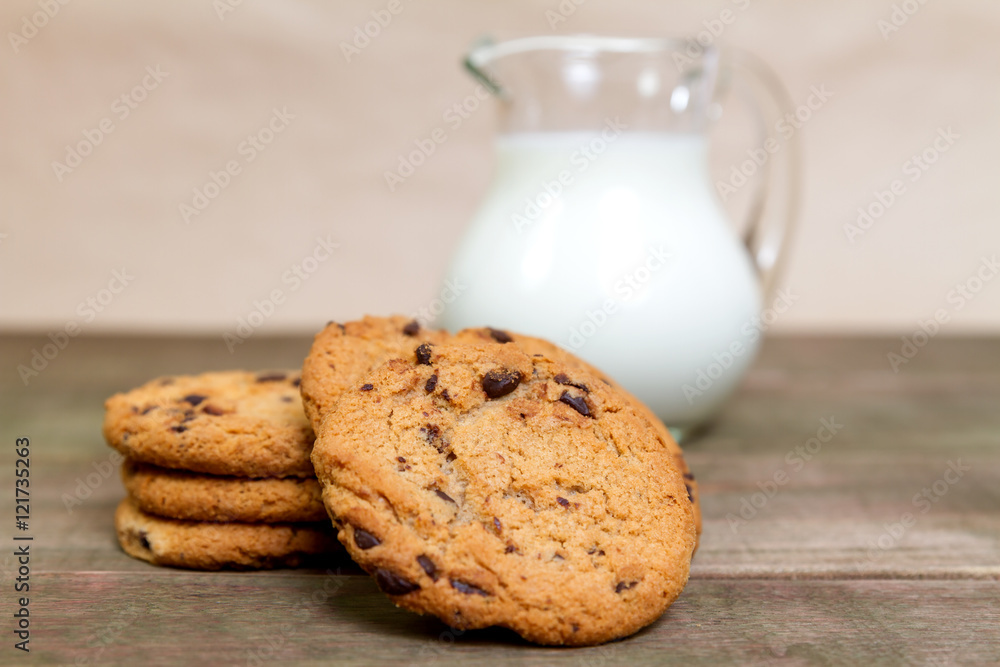 Homemade corn and oat biscuits with chocolate and milk in glass jug Homemade corn and oat biscuits with chocolate and milk in glass jug