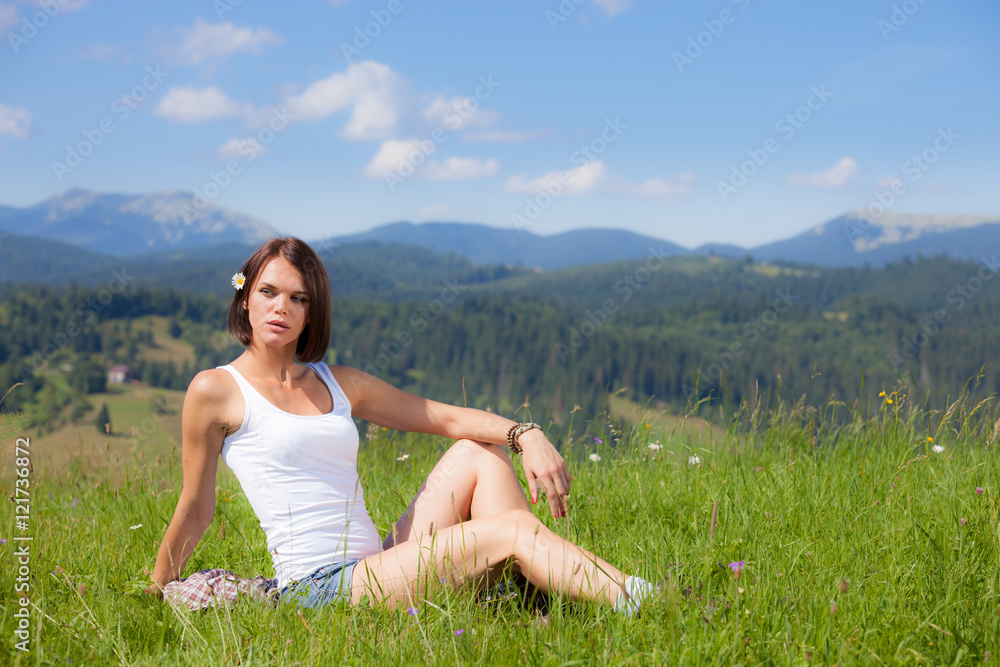 Beautiful girl lying on green grass field