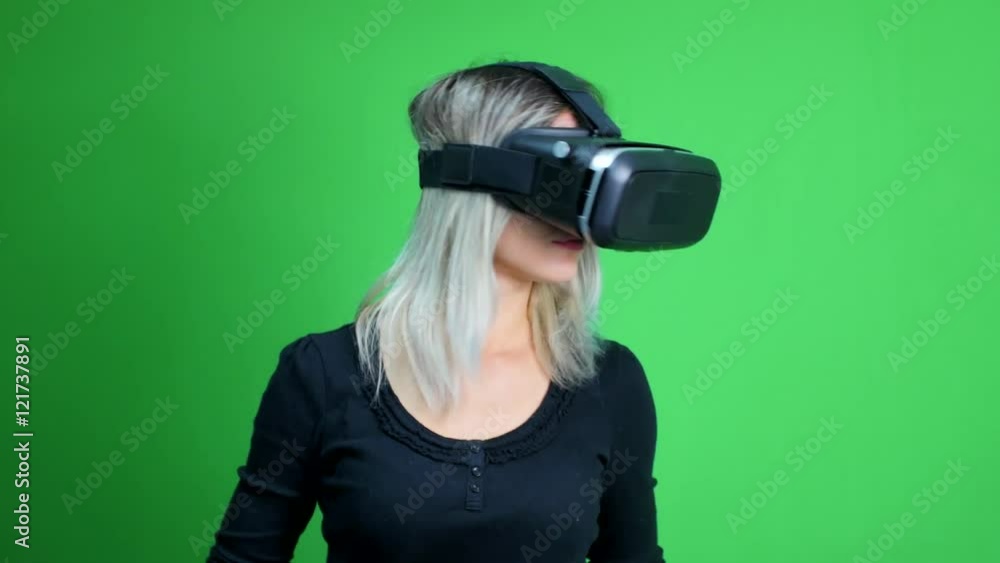 Young woman with a virtual reality head set on a green screen. Young woman with a virtual reality head set on a green screen.