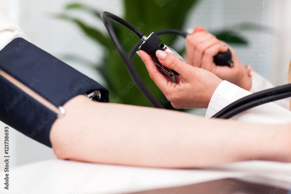 Female doctor checking his patient's blood pressure