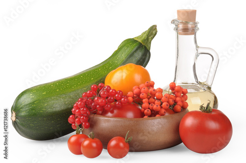 Fototapeta Naklejka Na Ścianę i Meble -  Autumn Still Life. The season of harvest. Zucchini, red and yellow tomatoes, berries of mountain ash and viburnum berries. Olive oil in a jug. . on a white background.