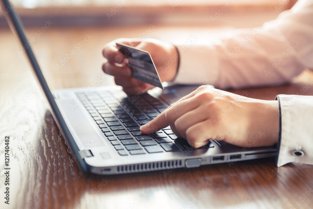 Hands holding credit card and using laptop - online shopping Hands holding credit card and using laptop - online shopping