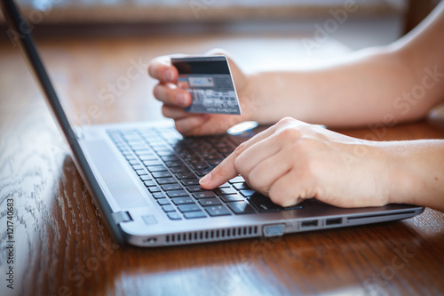 Hands holding credit card and using laptop - online shopping