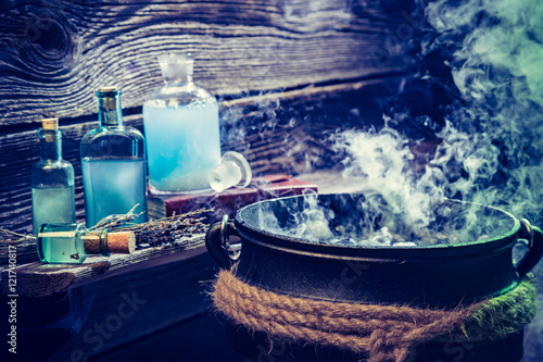 Old witch pot with blue potions for Halloween