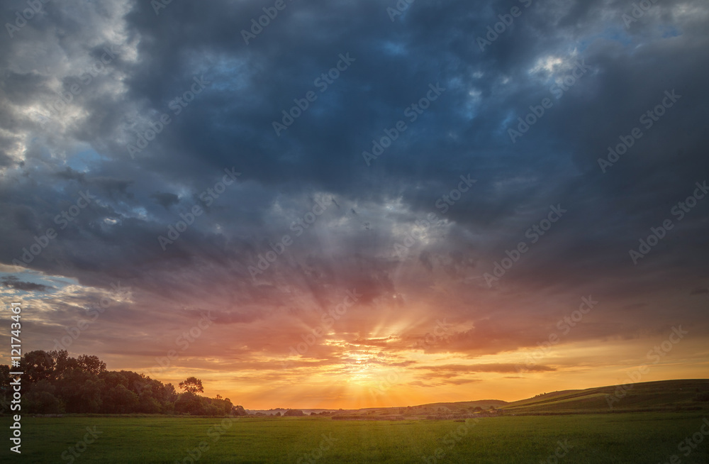 sunset over green meadow