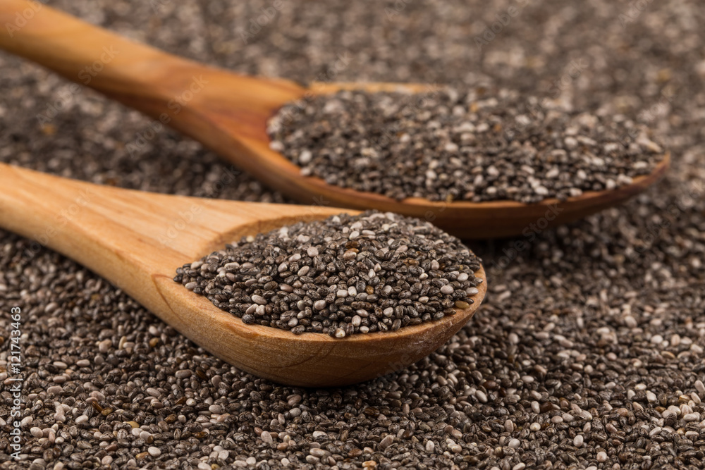 Chia seeds in wooden spoon Chia seeds in wooden spoon