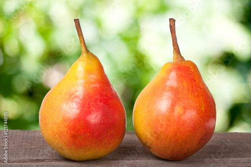 two pears on a dark wooden table with blurred background