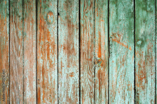 background consisting of old wooden boards with traces of peeling paint. partially tinted photo.
