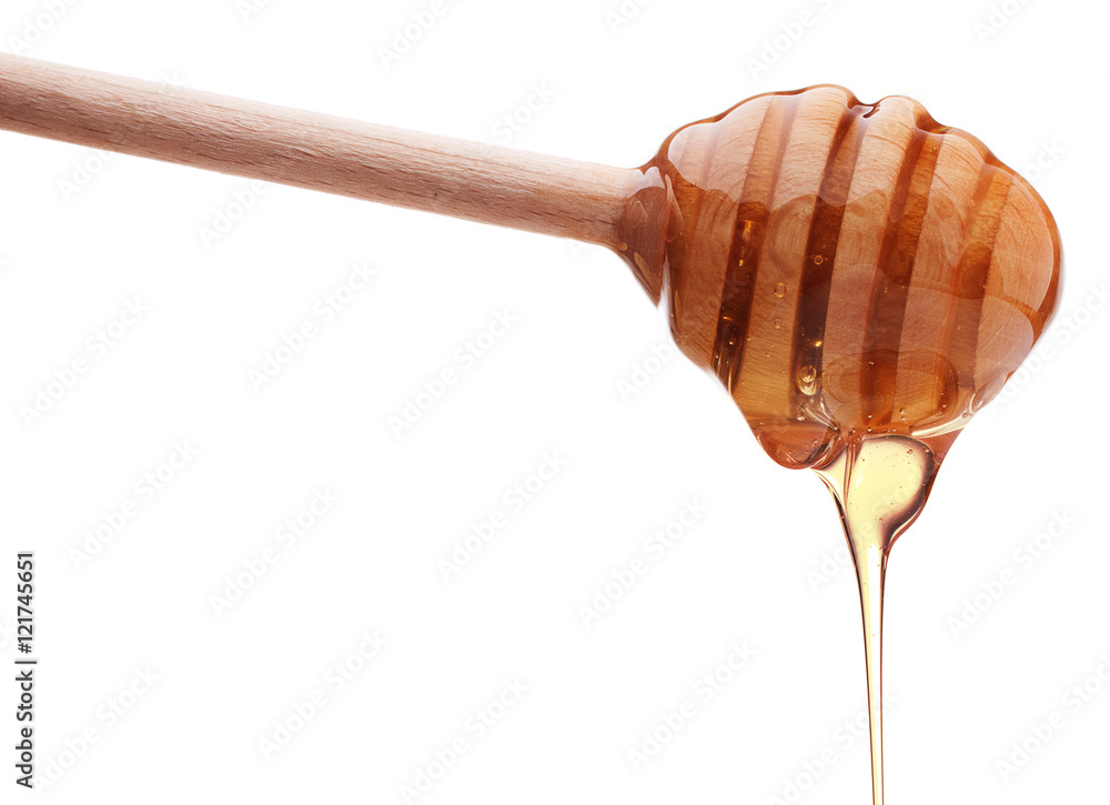Honey dripping from a wooden honey dipper isolated on white back Honey dripping from a wooden honey dipper isolated on white back