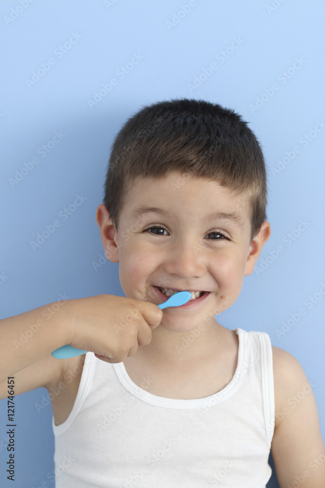 happy child brushing his teeth in a blue background happy child brushing his teeth in a blue background