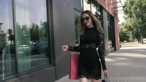 Wonderful woman is walking elegantly along the shop windows photo