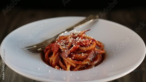 bucatini with amatriciana sauce in the dish in movement