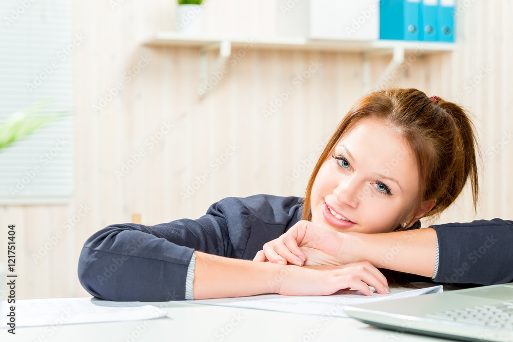 Smiling young secretary at a desk in the office resting Smiling young secretary at a desk in the office resting