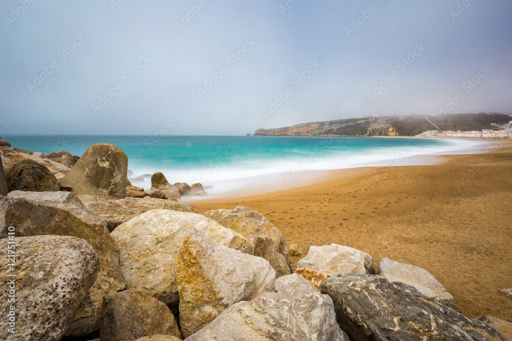 Long exposure seascape of sandy beach in Nazare, Portugal