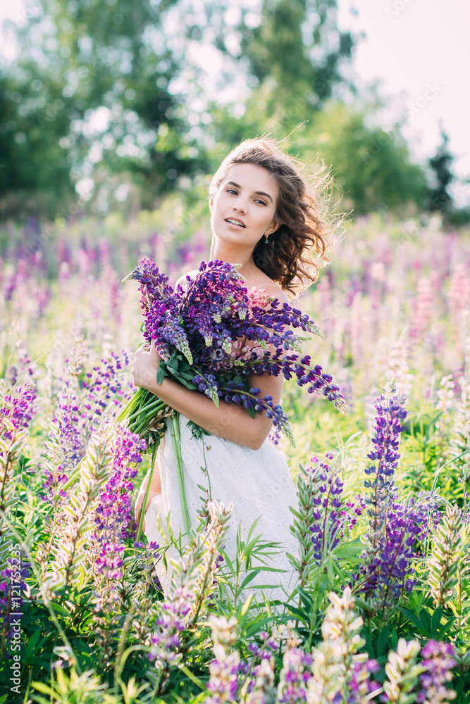 Girl with a bouquet of lupine on the field Girl with a bouquet of lupine on the field