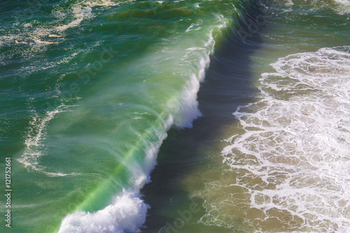 Top view of isolated emerald ocean waves with white foam, Praia do Norte, Nazare, Portugal