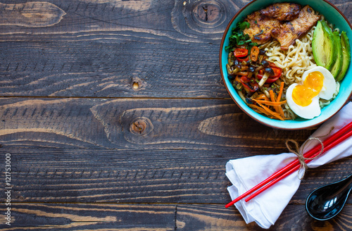 Japanese noodles bowl with chicken, carrots, avocado photo