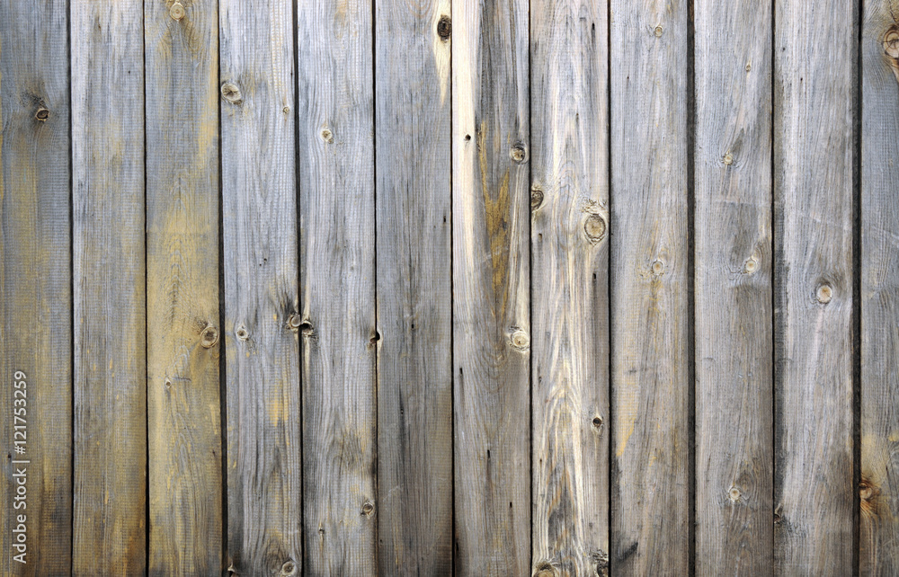 Naklejka premium Background from old boards with knots and scratches. traces of the influence of weather. partially tinted photo.