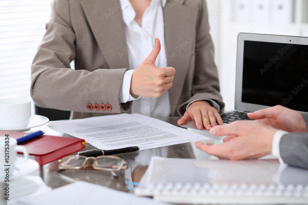 Group of business people or lawyers at meeting discussing contract papers. Woman showing thumb up Group of business people or lawyers at meeting discussing contract papers. Woman showing thumb up