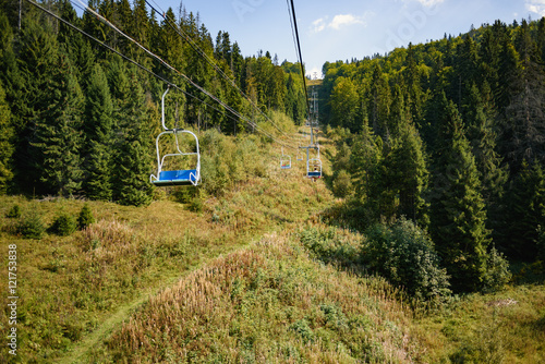 Lift seats in the Carpathians among spruce trees
