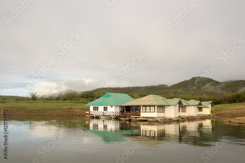 houseboat in lake and green mountain background