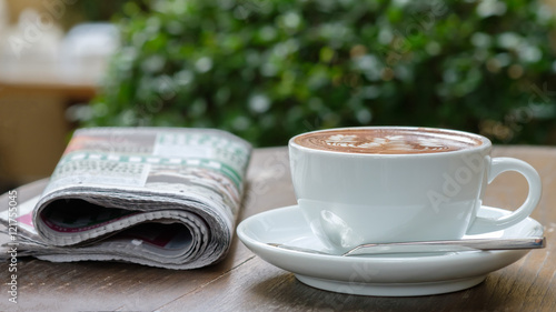 A cup of coffee on the table with newspaper