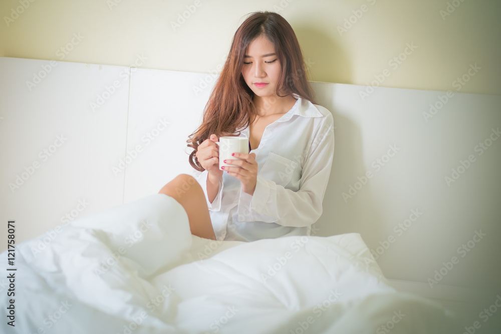Beautiful brunette woman drinking and morning coffee in bedroom Beautiful brunette woman drinking and morning coffee in bedroom