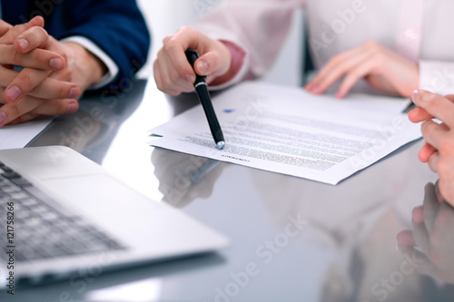 Group of business people and lawyers discussing contract papers sitting at the table, close up