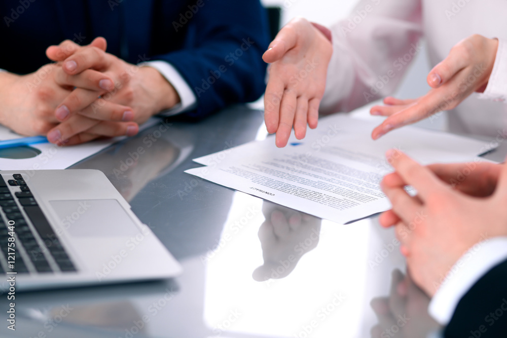 Group of business people and lawyers discussing contract papers sitting at the table, close up Group of business people and lawyers discussing contract papers sitting at the table, close up