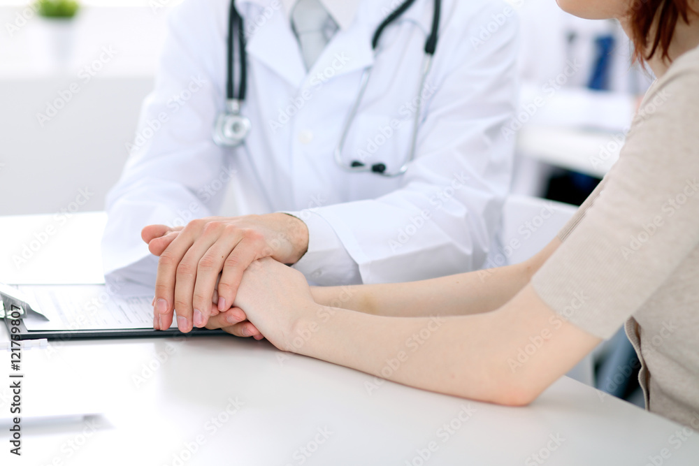 Hand of doctor reassuring her female patient Hand of doctor reassuring her female patient