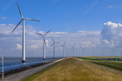 Row of windturbines along a dike photo