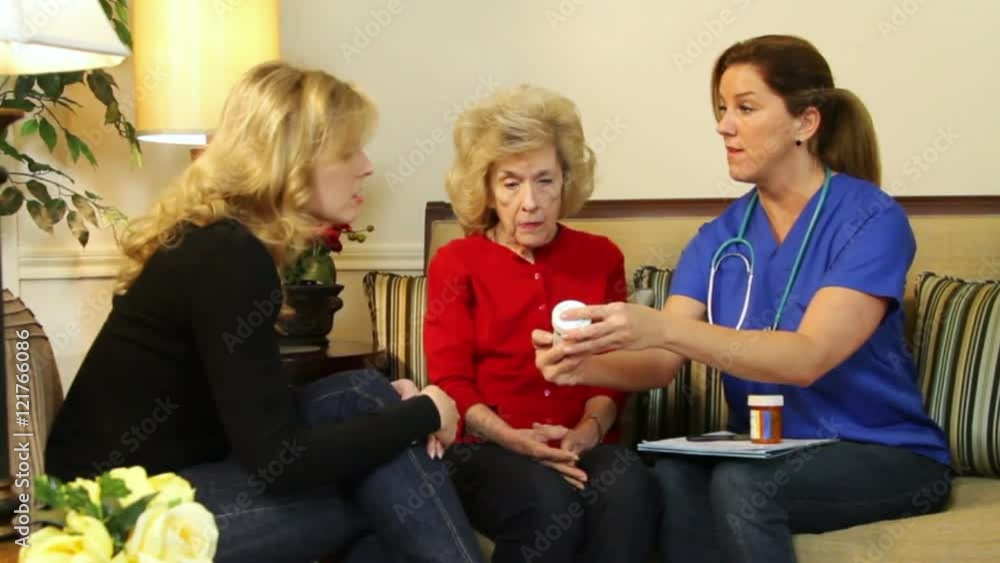 A pretty home health nurse discusses with an elderly patient and her daughter the prescribed medications. A pretty home health nurse discusses with an elderly patient and her daughter the prescribed medications.