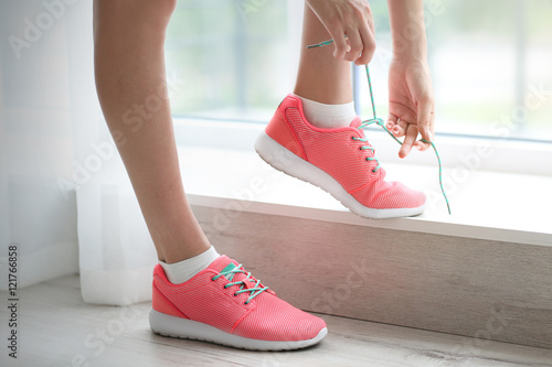 Woman tying her pink sneakers